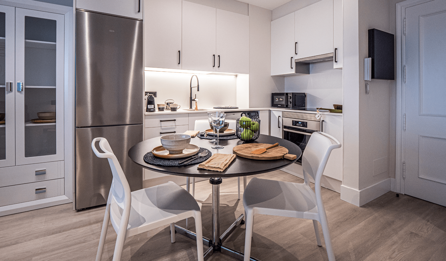Apartamentos turísticos Montrove_Galeria_Cocina con mobiliario blanco y gris y electrodomesticos en vivienda
