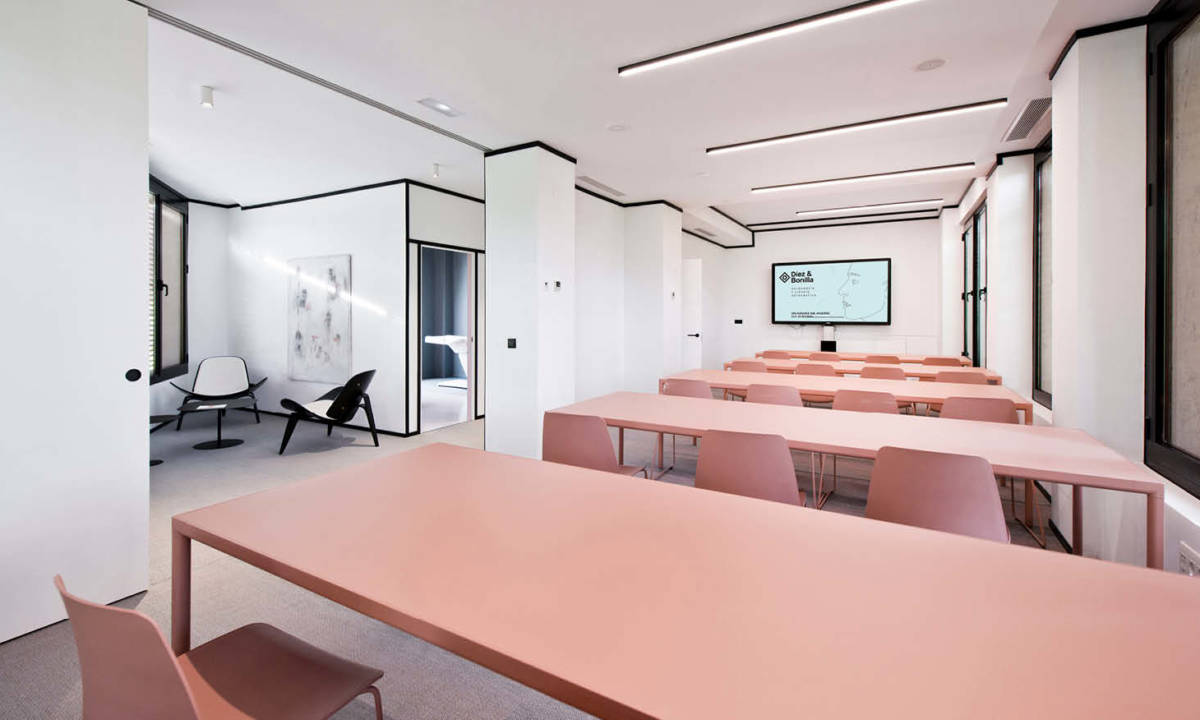 Zona de formacion con mobiliario rosa en clase dentro de clinica dental