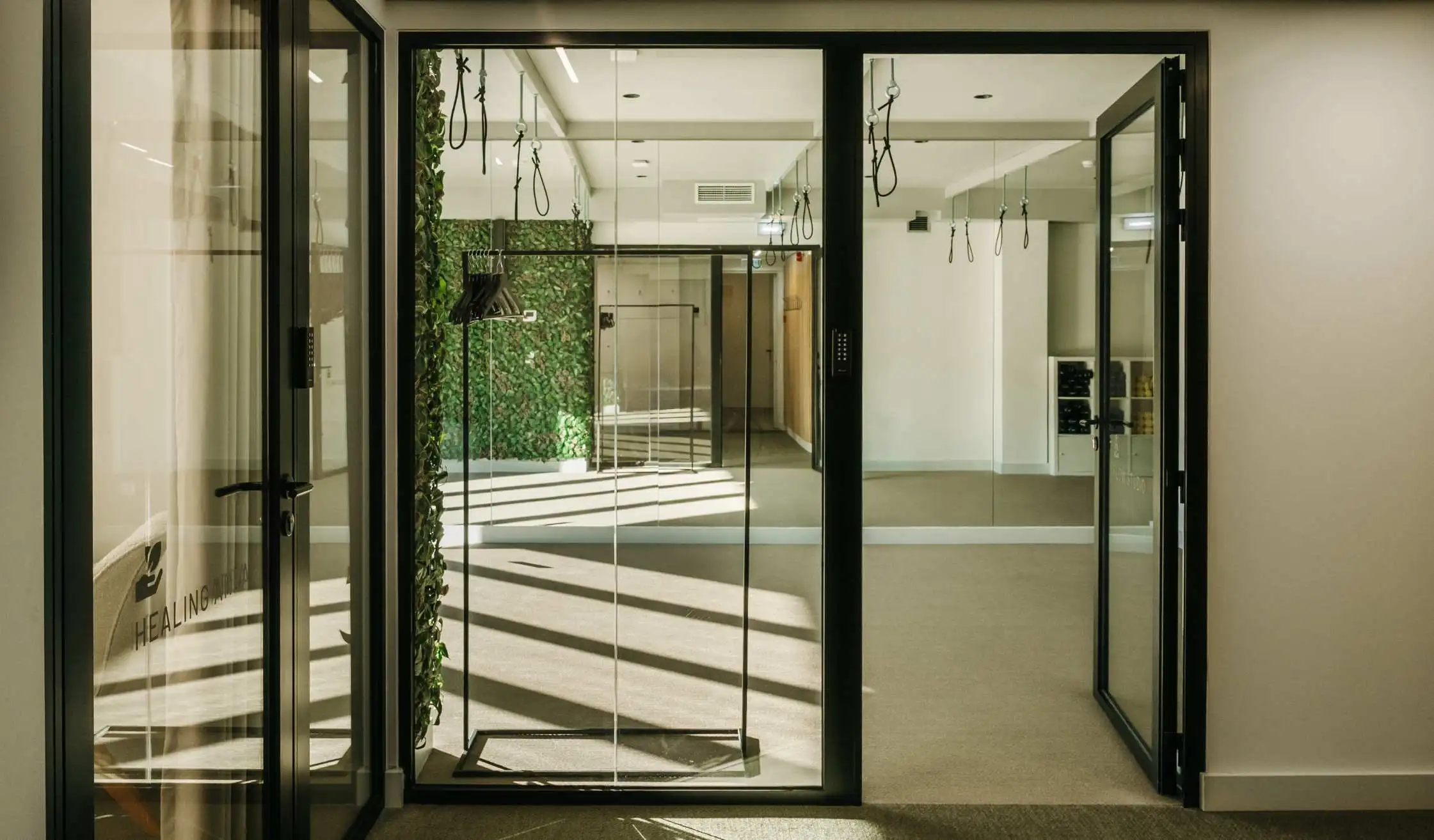 Mamparas de vidrio y metal con perfil negro en espacio Coworking