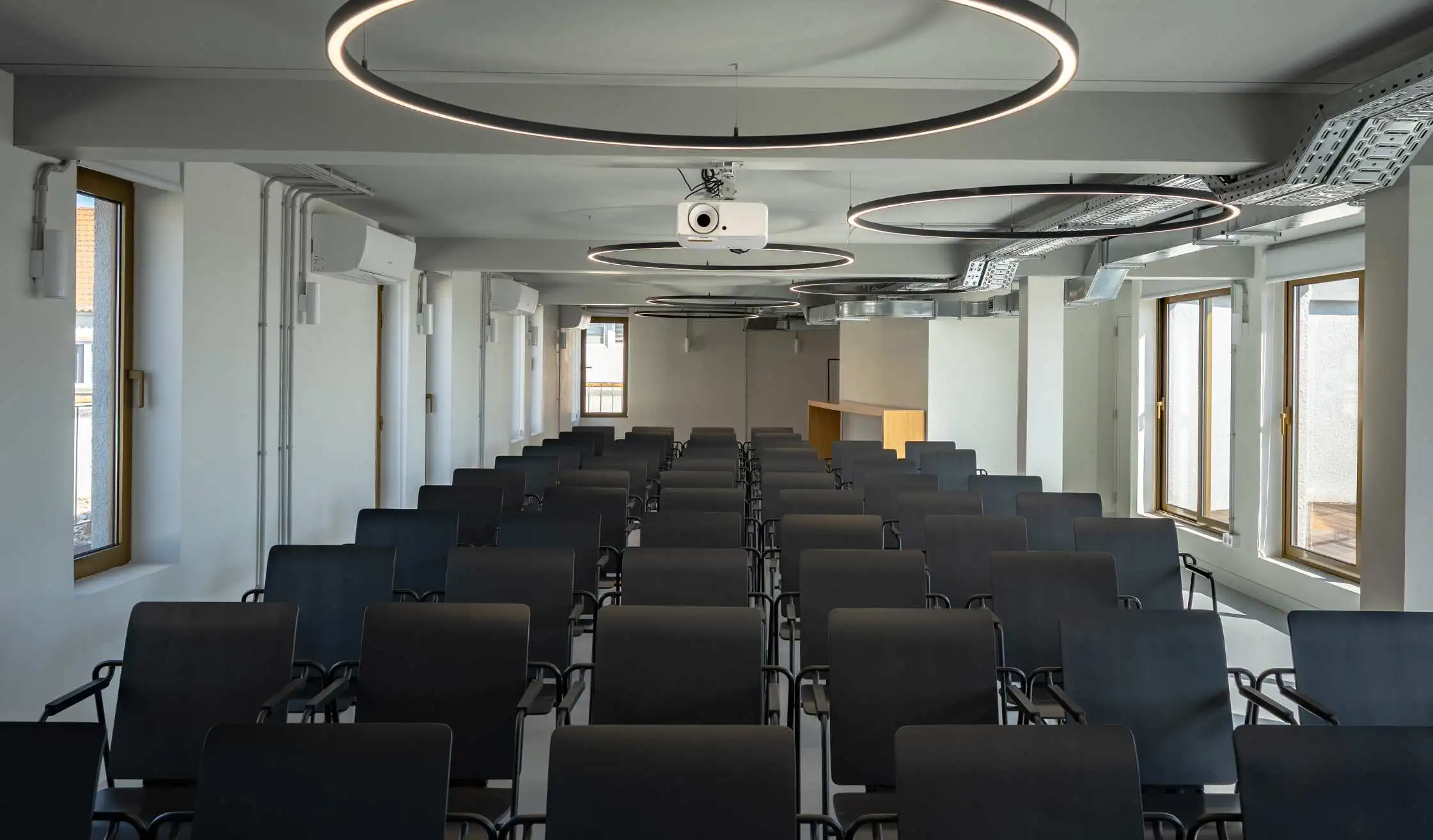 Sala de conferencias con sillas y mesas para presentaciones