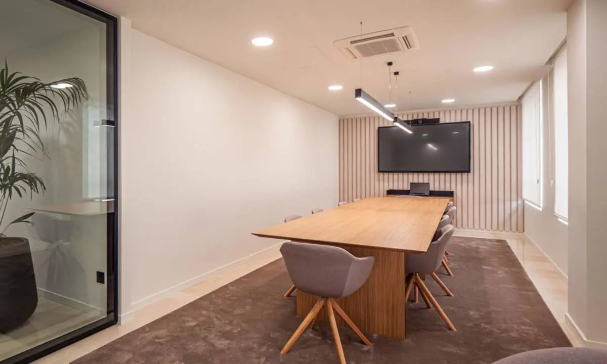 Sala de reuniones de gran tamaño con equipamiento audiovisual y panelado acústico