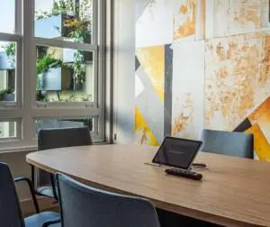 Espacio de reunión en oficina con pantallas audiovisuales y carpintería a medida