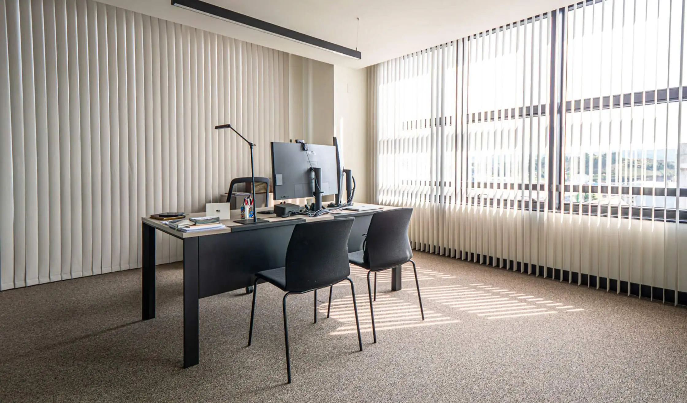 Despacho de trabajo en oficina con mobiliario y estores