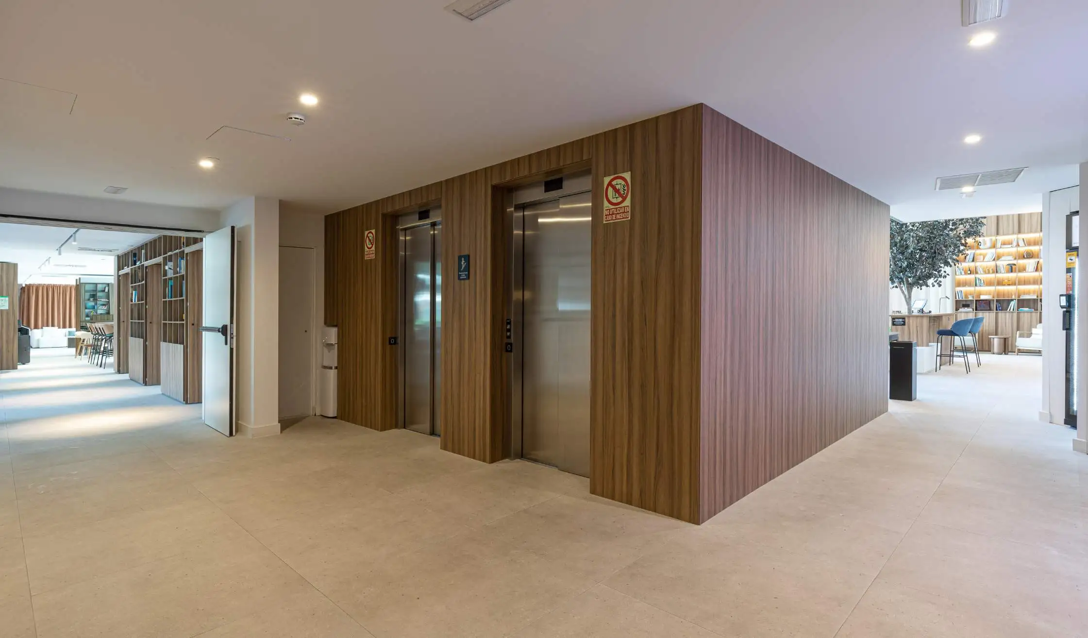 Zona de ascensores con carpintería a medida en revestimiento