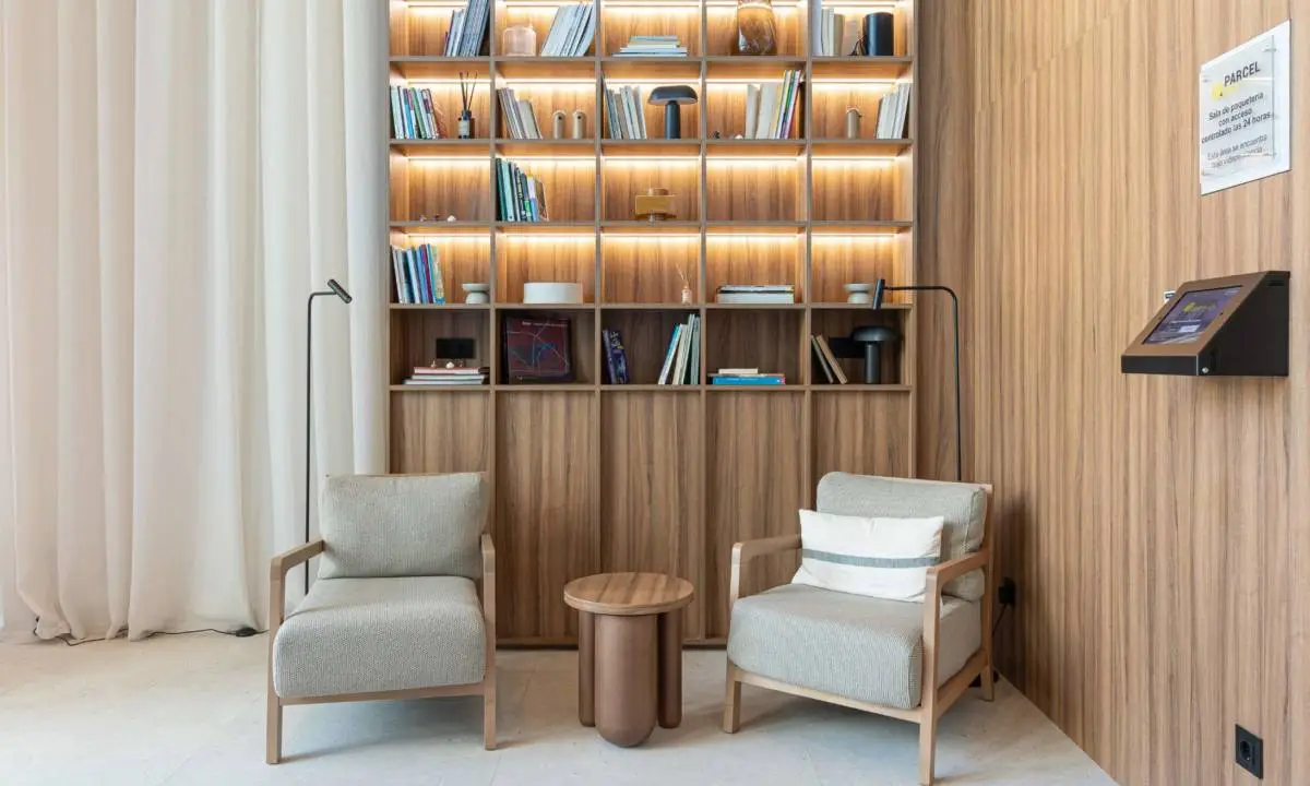 Estantería retroiluminada con butacas y madera hasta el techo