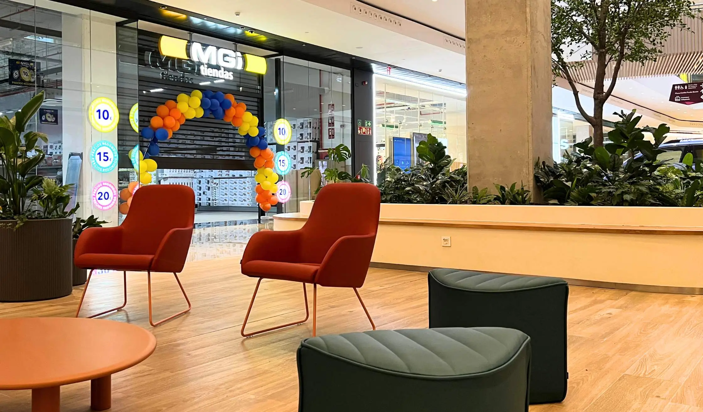 Butacas color rojo y pufs color azul para zona común de centro comercial