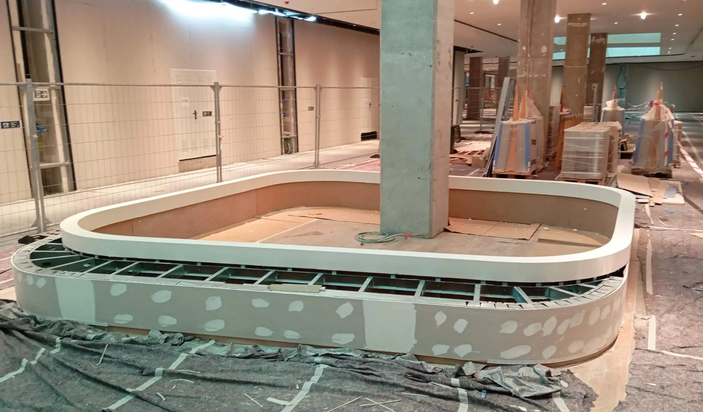 Centro comercial con proceso de obra de colocación de jardineras de carpintería a medida